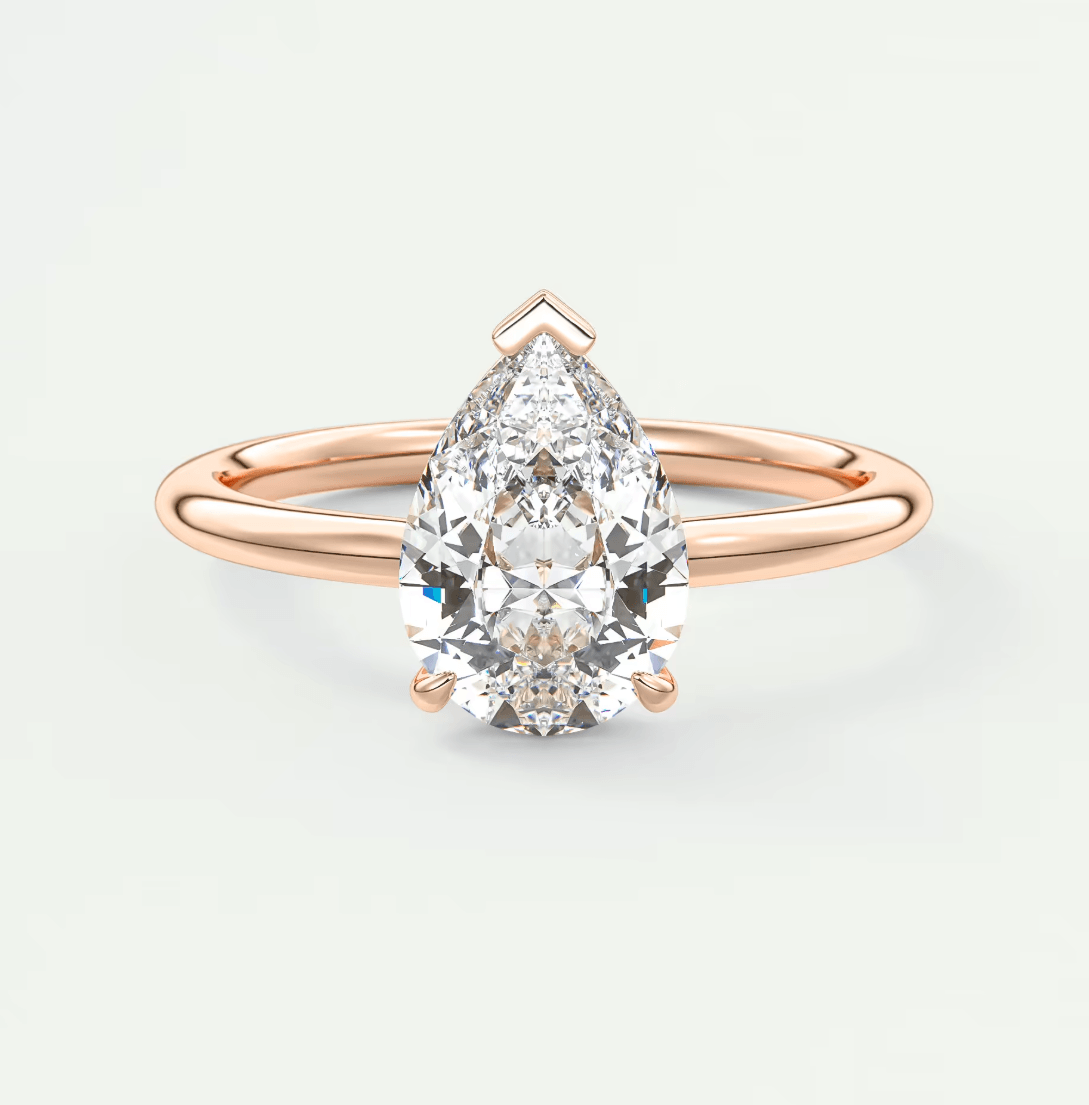 Rose gold pear-shaped diamond engagement ring with a solitaire design.