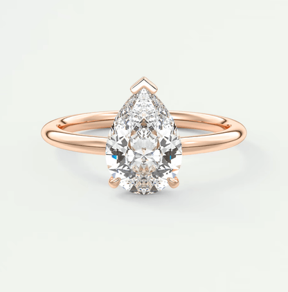 Rose gold pear-shaped diamond engagement ring with a solitaire design.