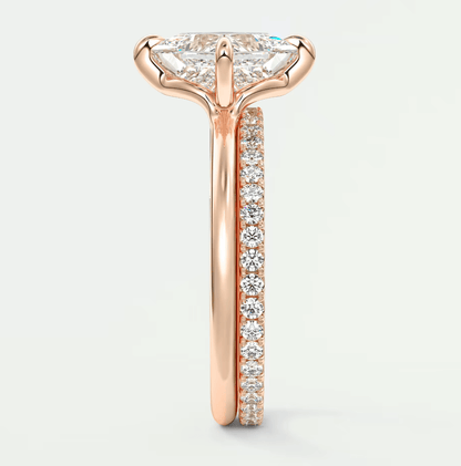 18k rose gold engagement ring with marquise diamond center stone and pavé diamonds on band.