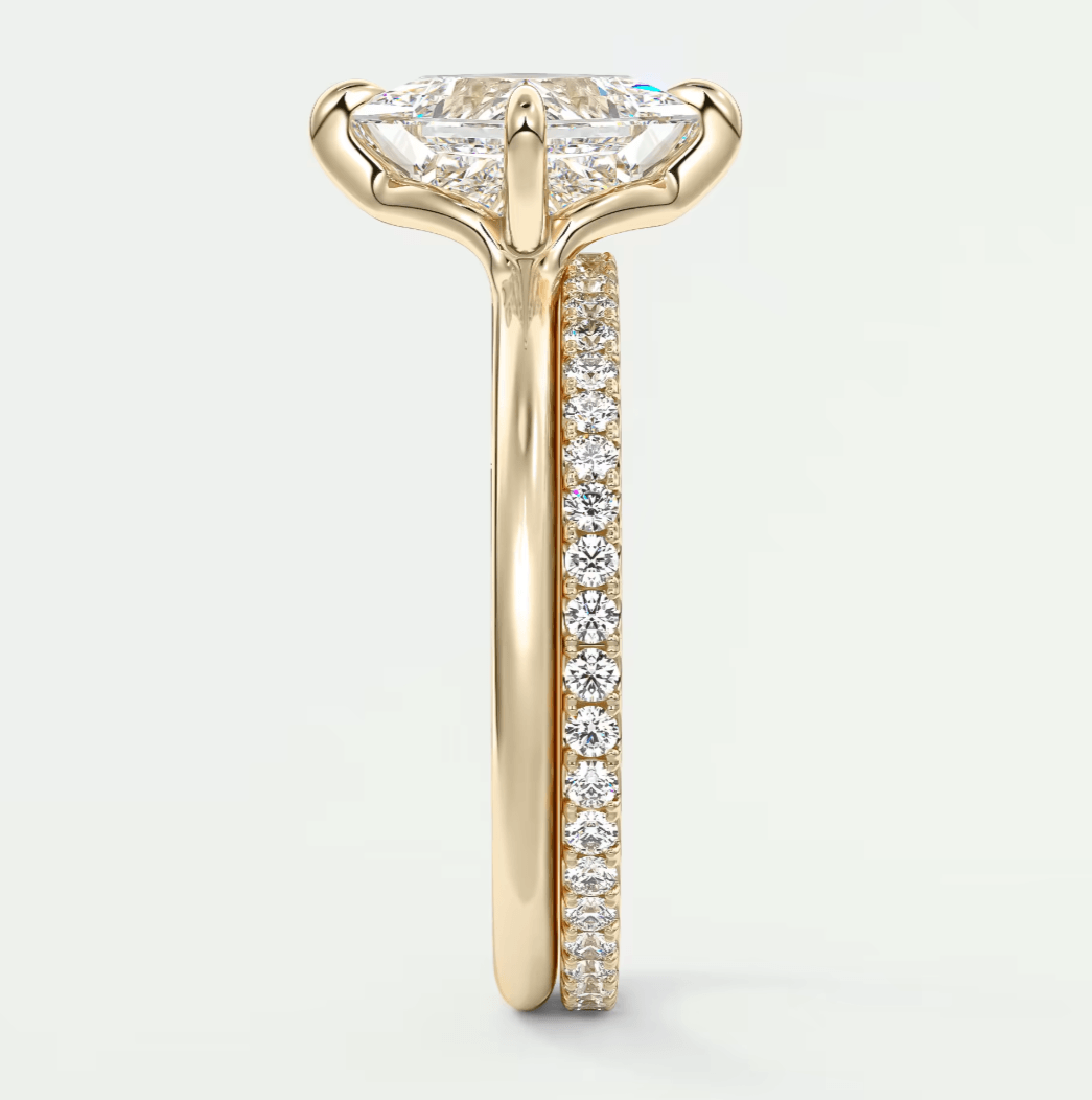 18k yellow gold engagement ring with a marquise-cut diamond and pave-set diamonds on the band.