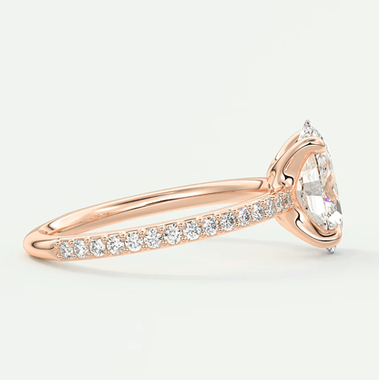 18k rose gold diamond engagement ring with a marquise-cut center stone and pave set diamonds on the band.