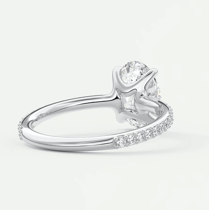 18k white gold diamond engagement ring with a pear-shaped center stone and round side stones.