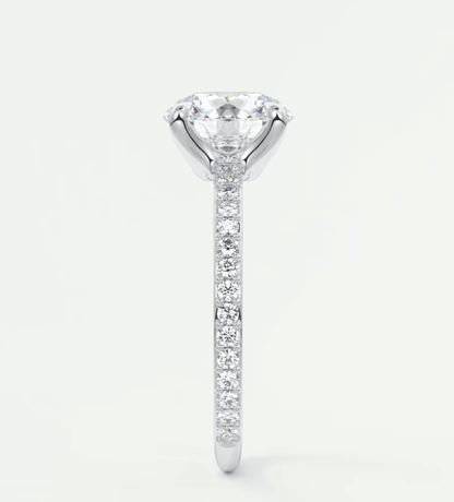 18-karat white gold diamond engagement ring with a round brilliant cut center stone and pave-set diamonds on the band.