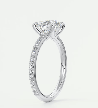 18k white gold diamond engagement ring with a round brilliant cut center stone and pave set diamonds on the band.