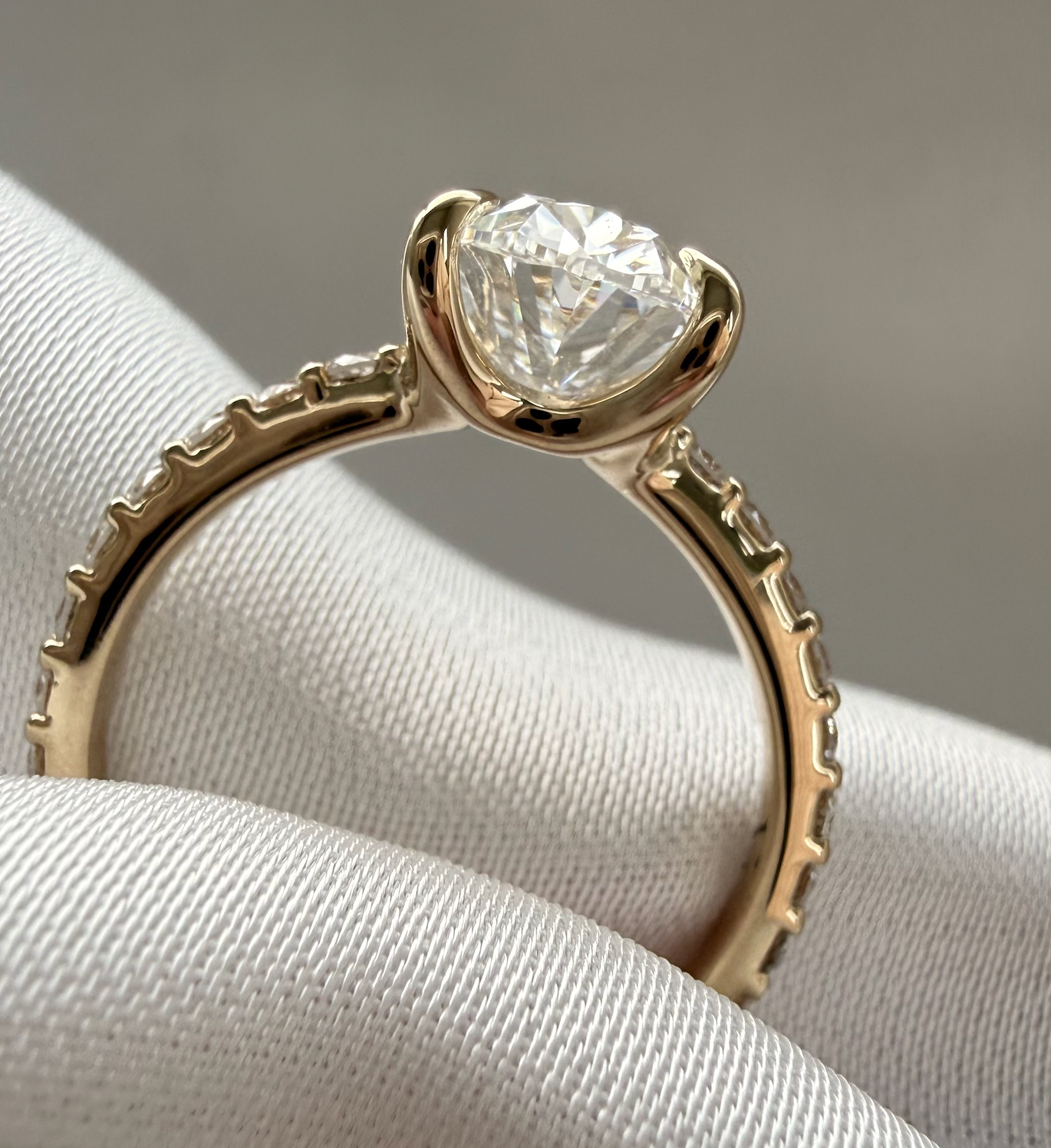 Gold ring with a diamond on a soft fabric background