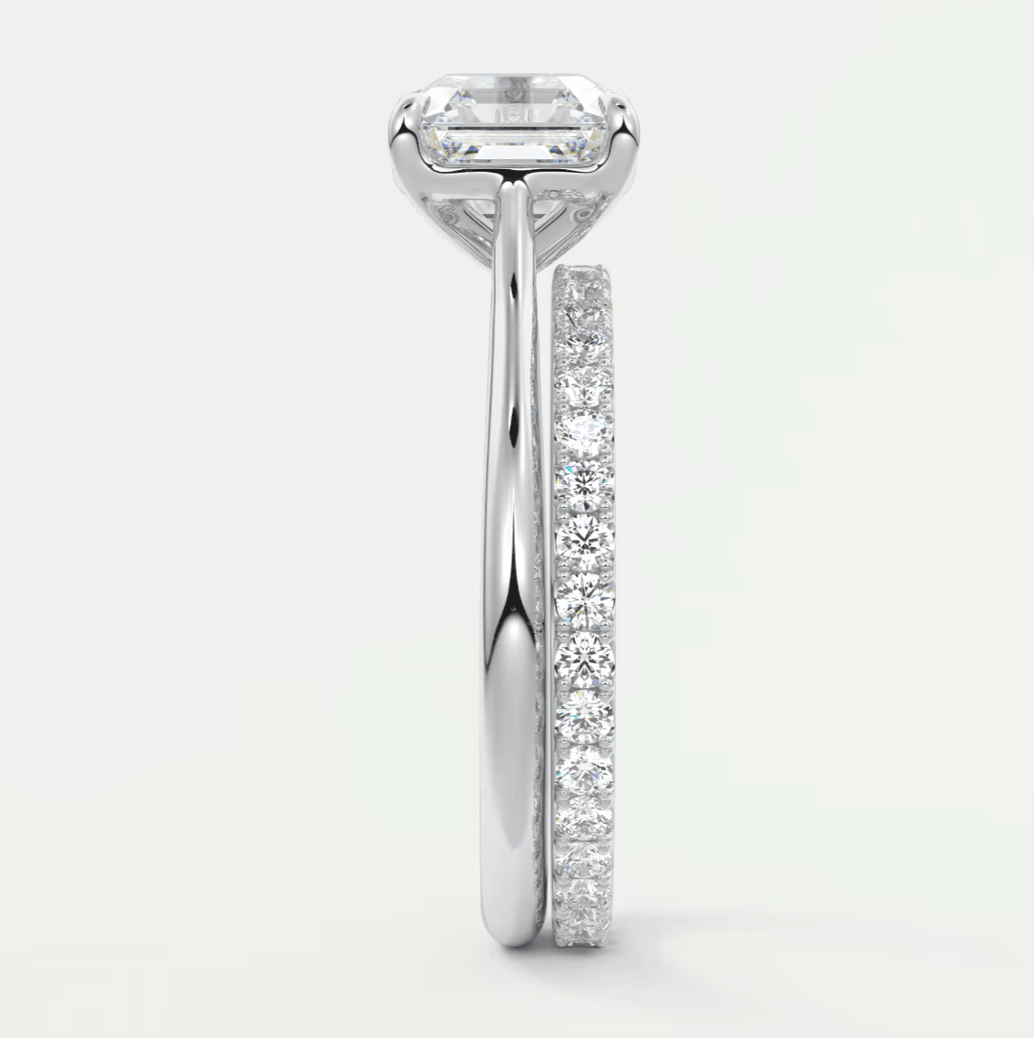 18k white gold engagement ring with emerald-cut diamond and pave set diamonds on band.