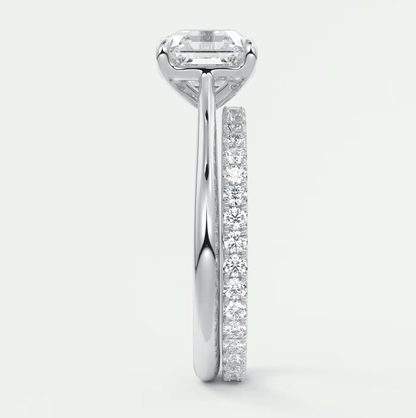 18k white gold engagement ring with emerald-cut diamond and pave set diamonds on band.