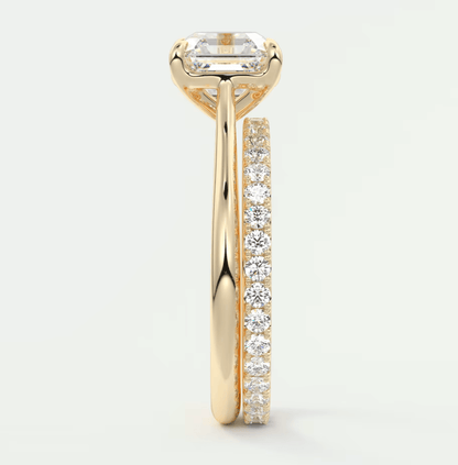 18k yellow gold engagement ring with emerald-cut diamond and channel-set diamonds, featuring a sleek modern design.