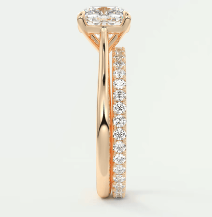 18k rose gold diamond engagement ring with a princess cut center stone and pave set side stones.