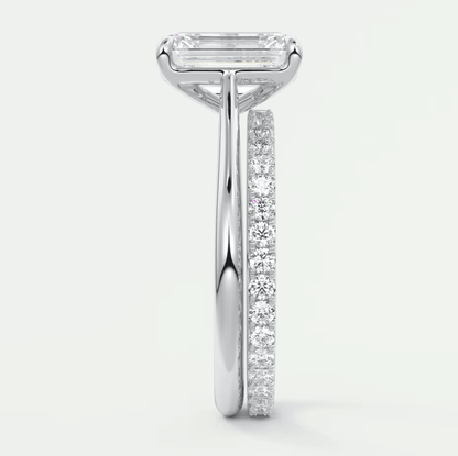 18k white gold engagement ring with an emerald-cut diamond and a pave-set band.
