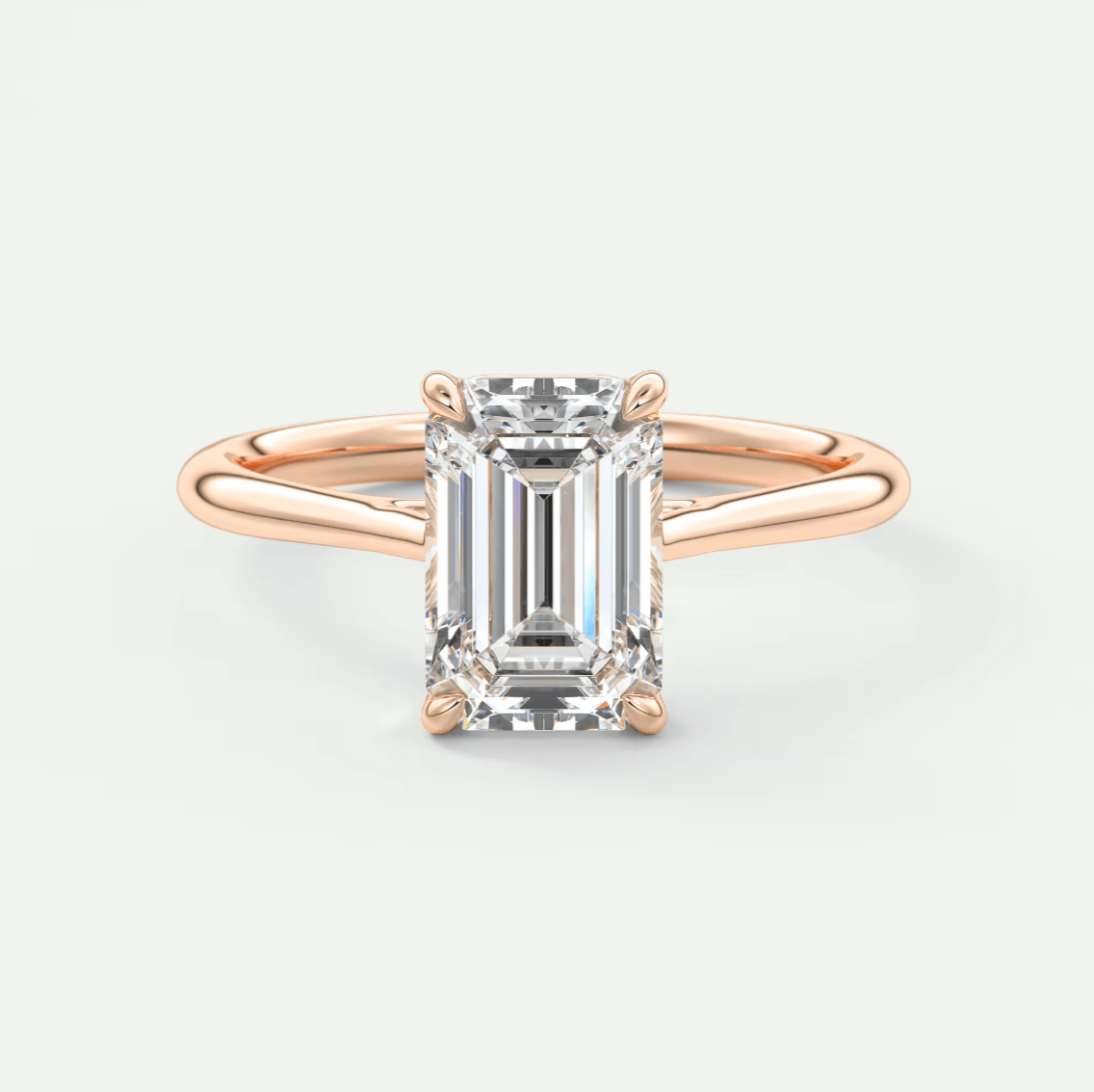 18-karat rose gold emerald-cut diamond engagement ring.