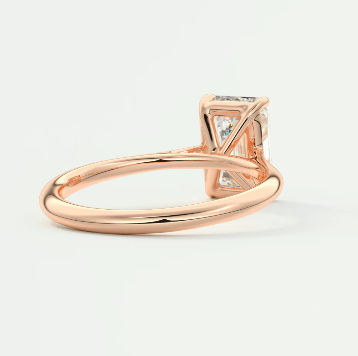 Rose gold diamond engagement ring with princess cut center stone and side diamonds, featuring a classic solitaire design.