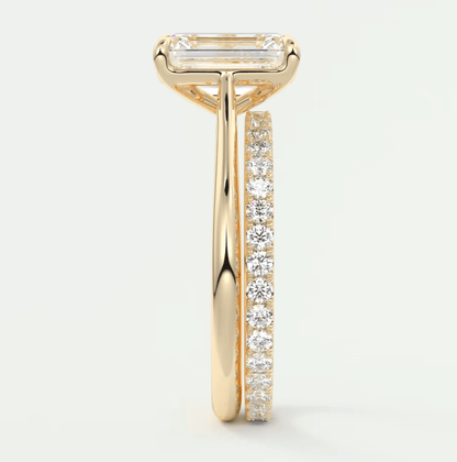 18k yellow gold diamond engagement ring with a baguette center stone and channel set diamonds on the band.