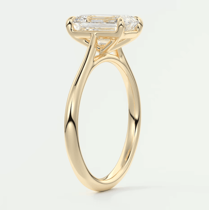 18k yellow gold engagement ring with a rectangular diamond center and baguette diamonds on the band.