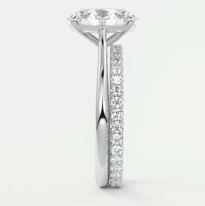 18-karat white gold engagement ring with a round diamond center and pavé-set diamonds on the band.
