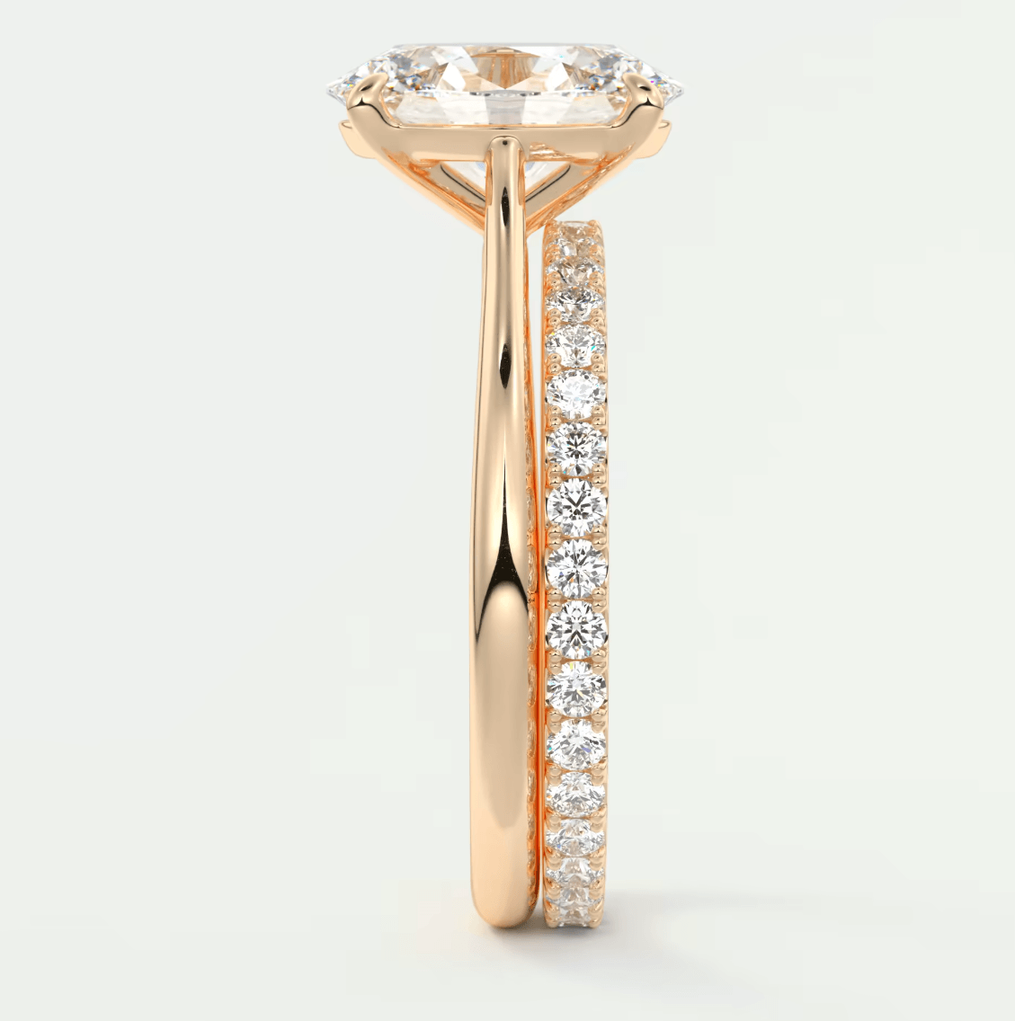 18-karat rose gold engagement ring with a round diamond center and channel-set diamonds on the band.