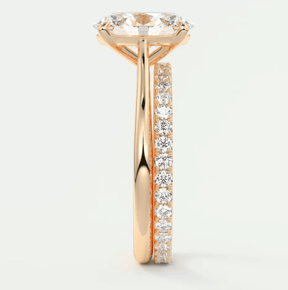 18-karat rose gold engagement ring with a round diamond center and channel-set diamonds on the band.