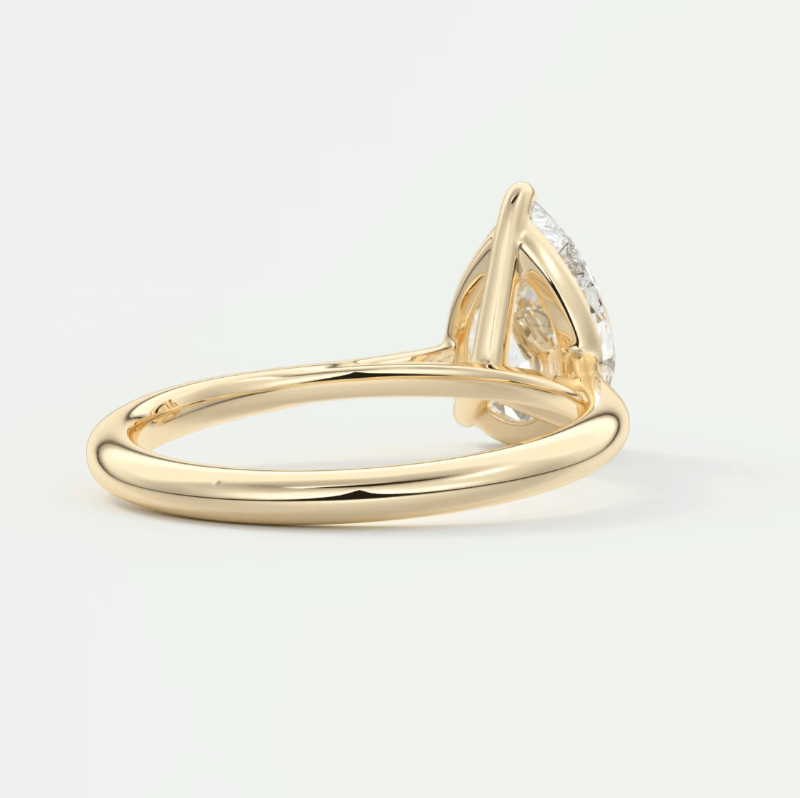 18-karat gold engagement ring with a pear-shaped diamond.