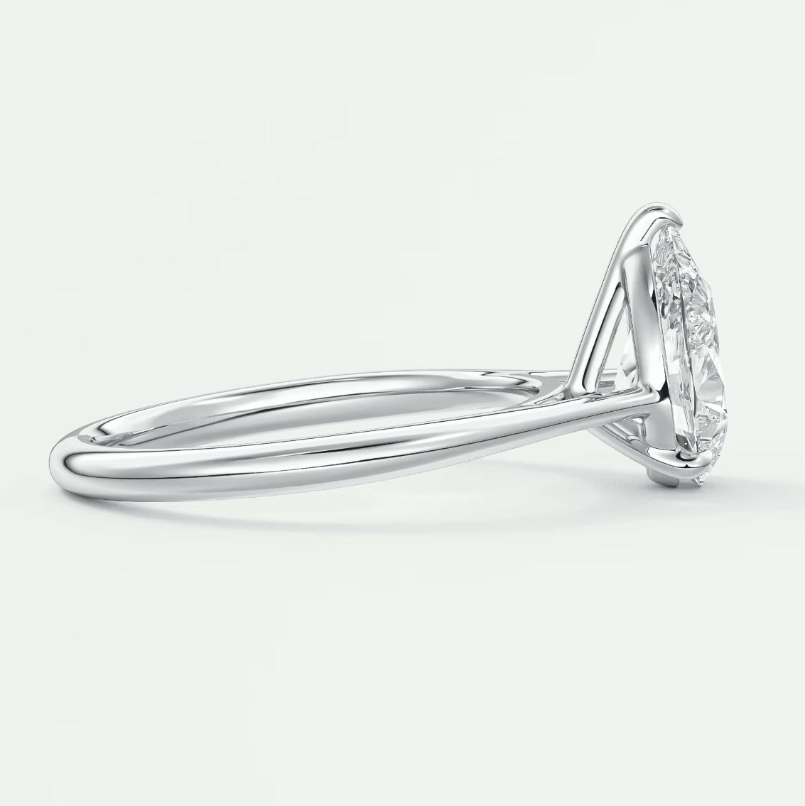 18-karat white gold diamond engagement ring with a marquise-cut center stone and small diamonds on the band.