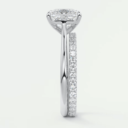 18k white gold diamond engagement ring with a cushion-cut center stone and pavé set diamonds on the band.