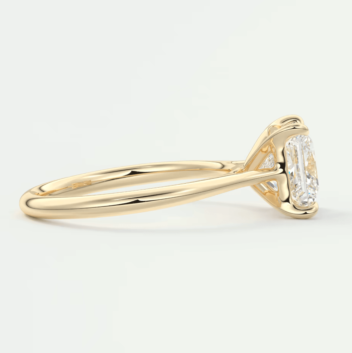 18k yellow gold diamond engagement ring with a baguette-cut center stone and side diamonds.