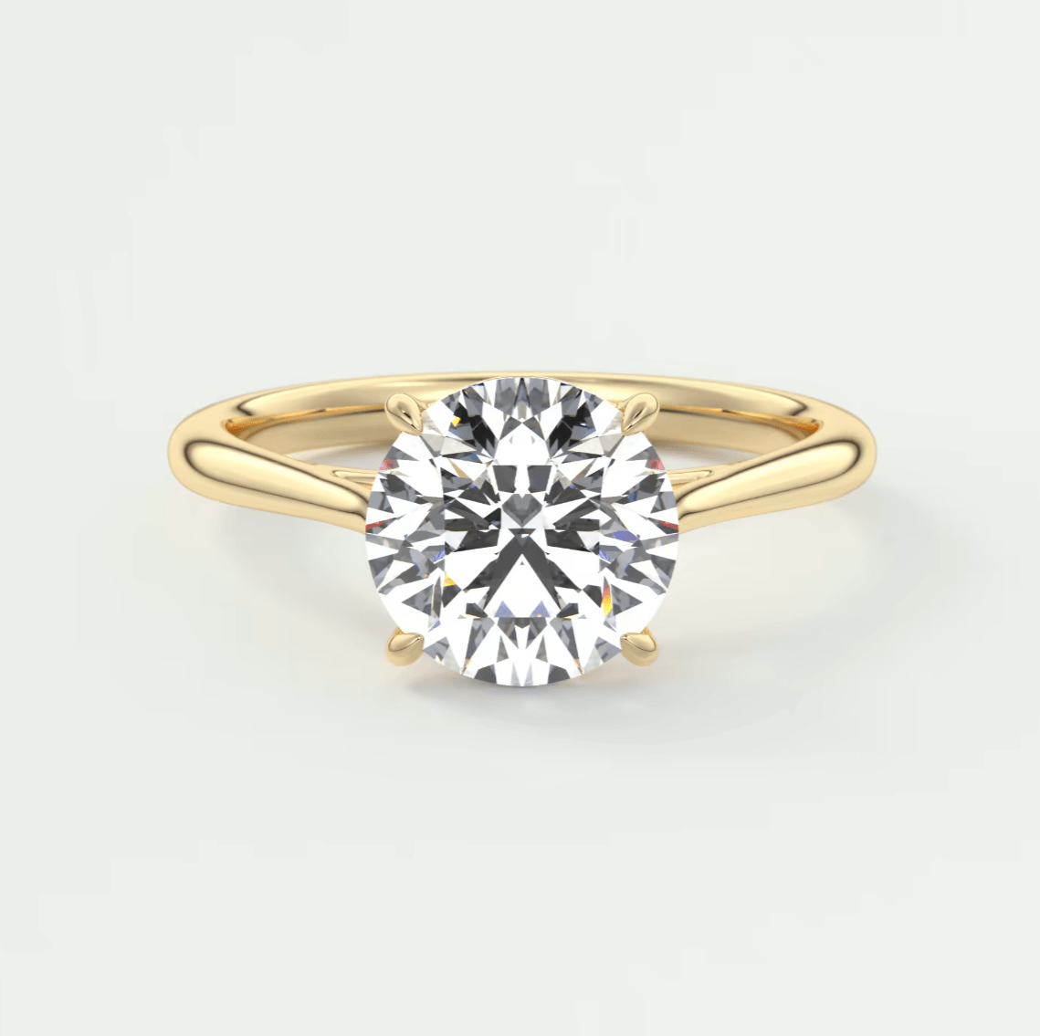 18-karat gold solitaire diamond engagement ring with a round-cut stone.