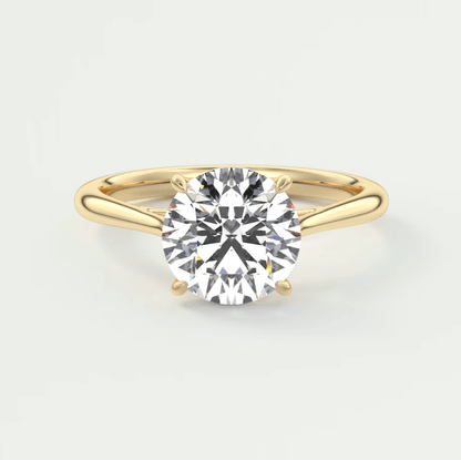 18-karat gold solitaire diamond engagement ring with a round-cut stone.