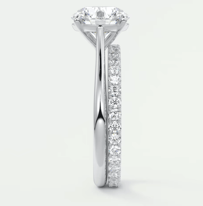 18-karat white gold diamond engagement ring with a round brilliant cut center stone and channel set diamonds on the band.
