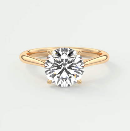 18-karat gold solitaire diamond engagement ring with a round-cut gemstone.