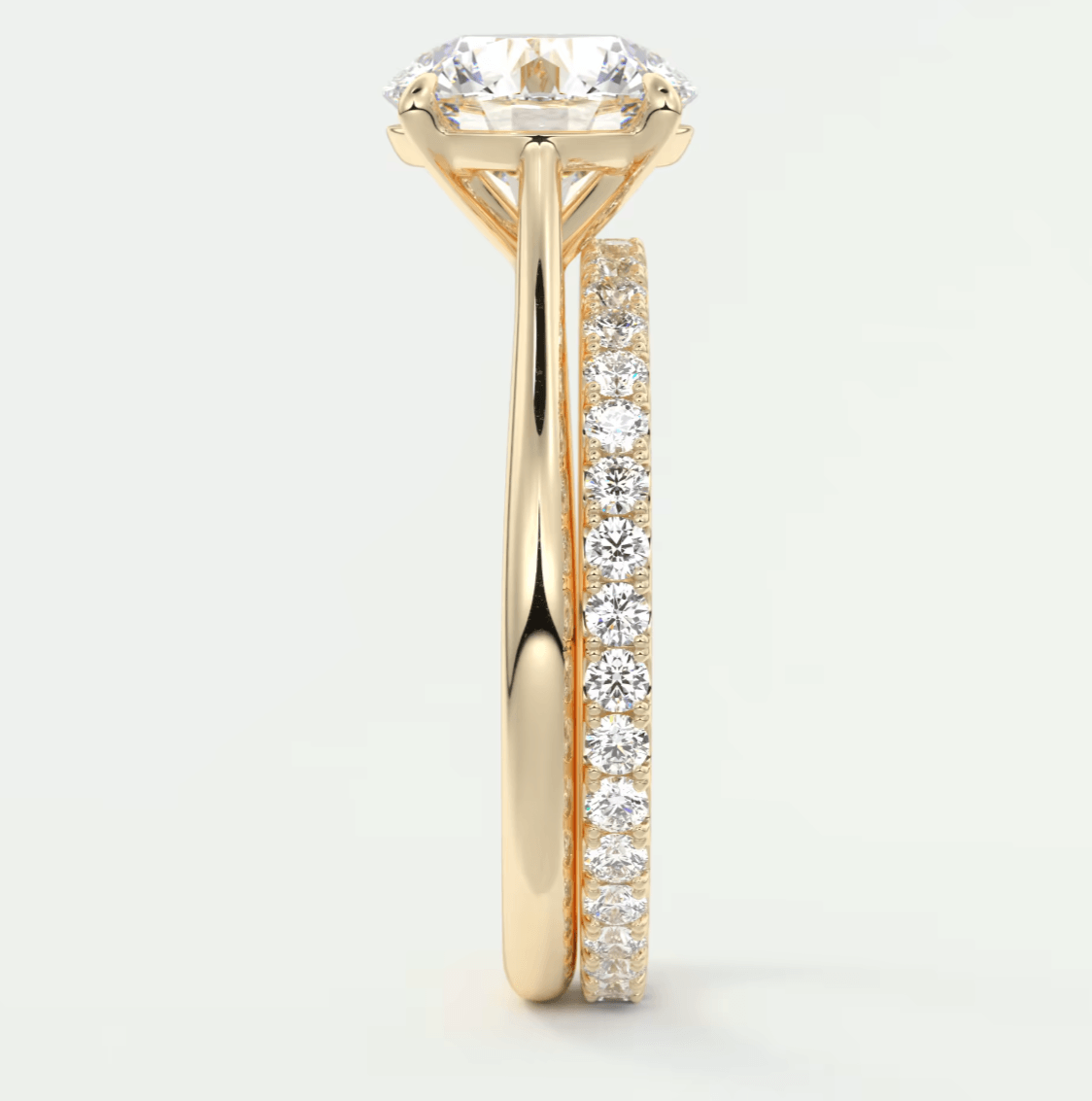 18k yellow gold engagement ring with a round diamond center stone and pave set diamonds on the band.