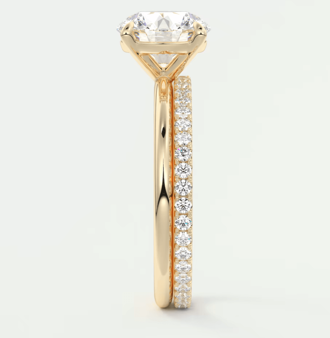 18k yellow gold diamond engagement ring with a round brilliant cut center stone and pavé side stones.