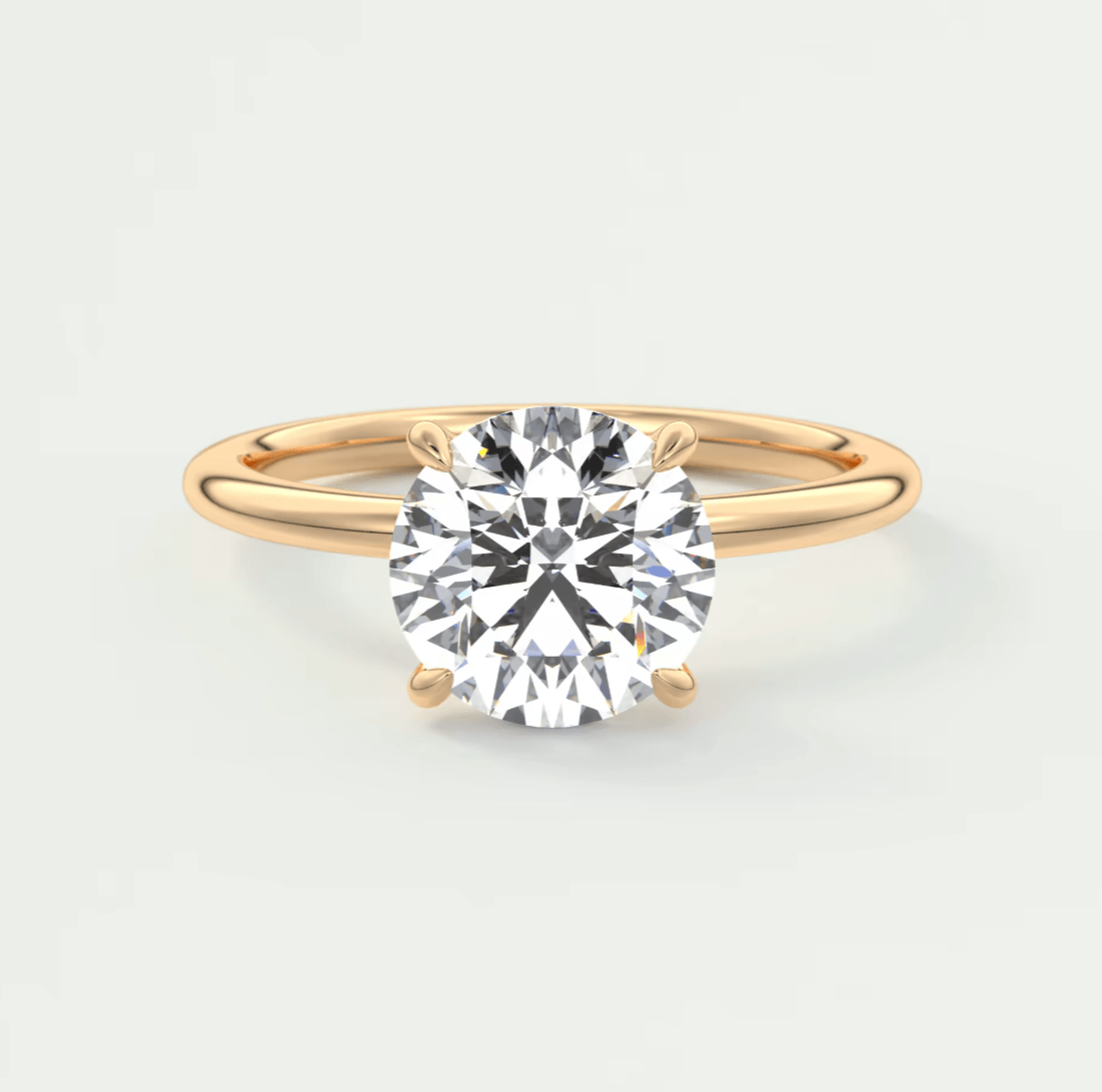 18-karat gold solitaire diamond engagement ring with a round brilliant cut stone.