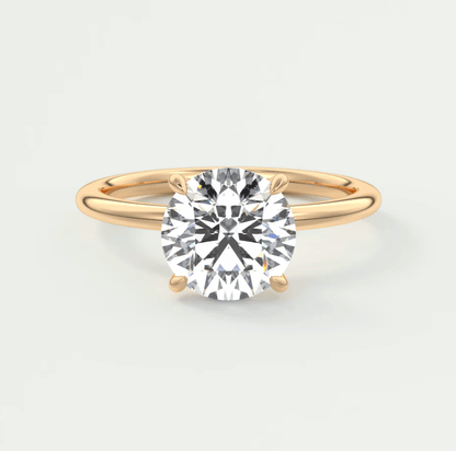 18-karat gold solitaire diamond engagement ring with a round brilliant cut stone.