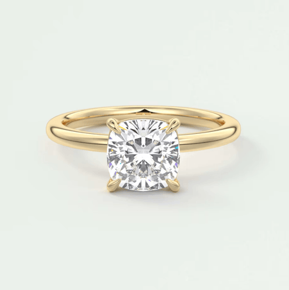 18k yellow gold solitaire diamond engagement ring with a cushion-cut center stone.