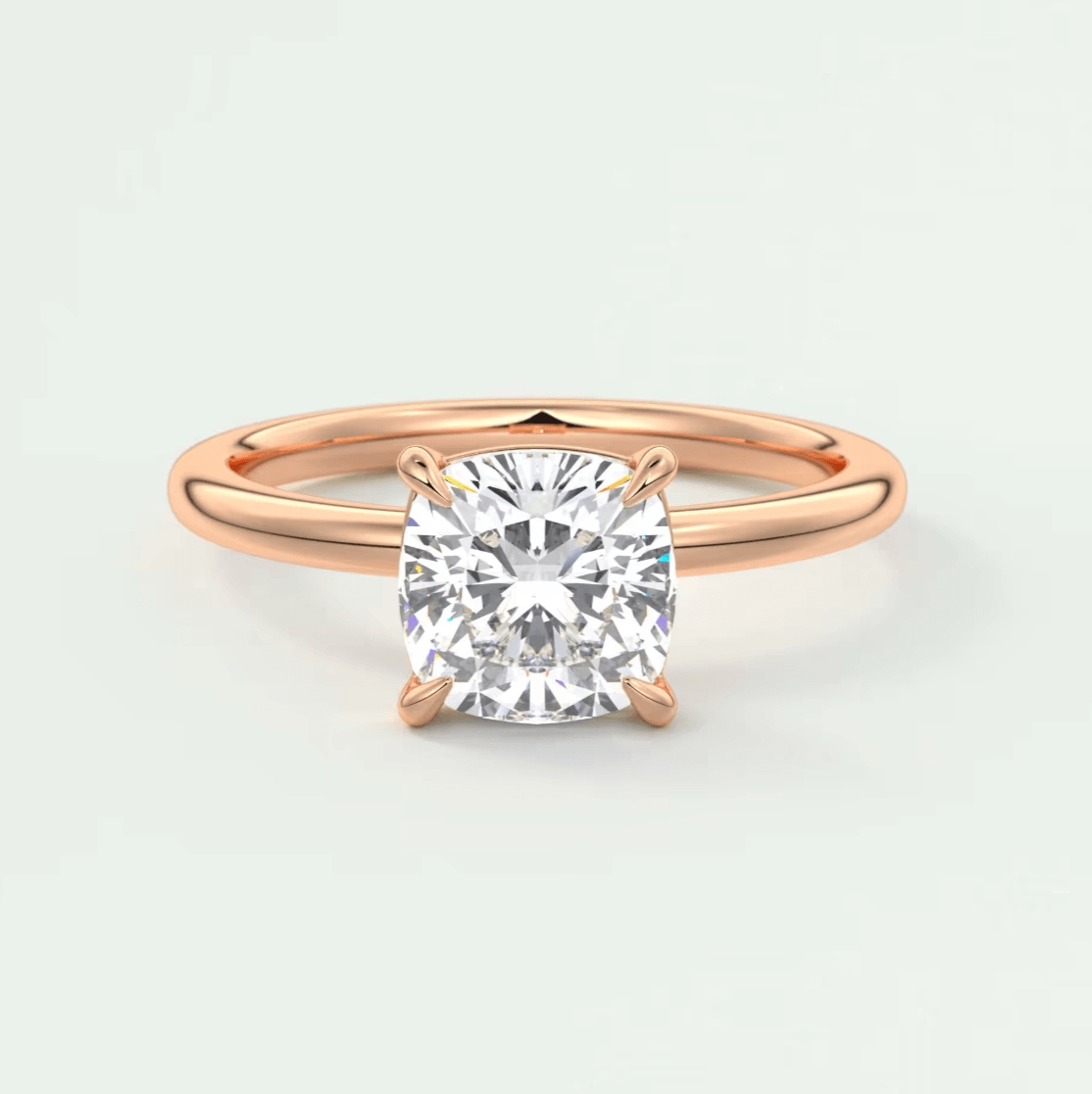 Rose gold cushion-cut diamond engagement ring with four prongs.
