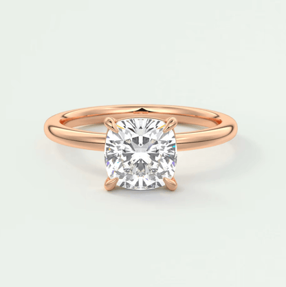 Rose gold cushion-cut diamond engagement ring with four prongs.