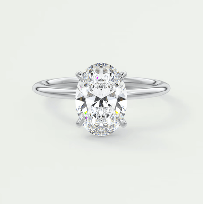 18k white gold oval diamond engagement ring with a princess cut center stone.