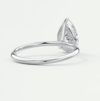 Pear-shaped diamond engagement ring with a white gold band and intricate milgrain detailing.