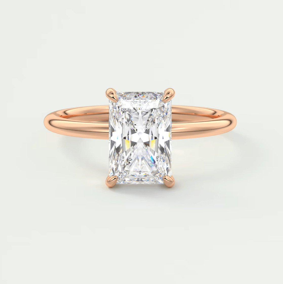 Rose gold diamond engagement ring with a rectangular cut gemstone.