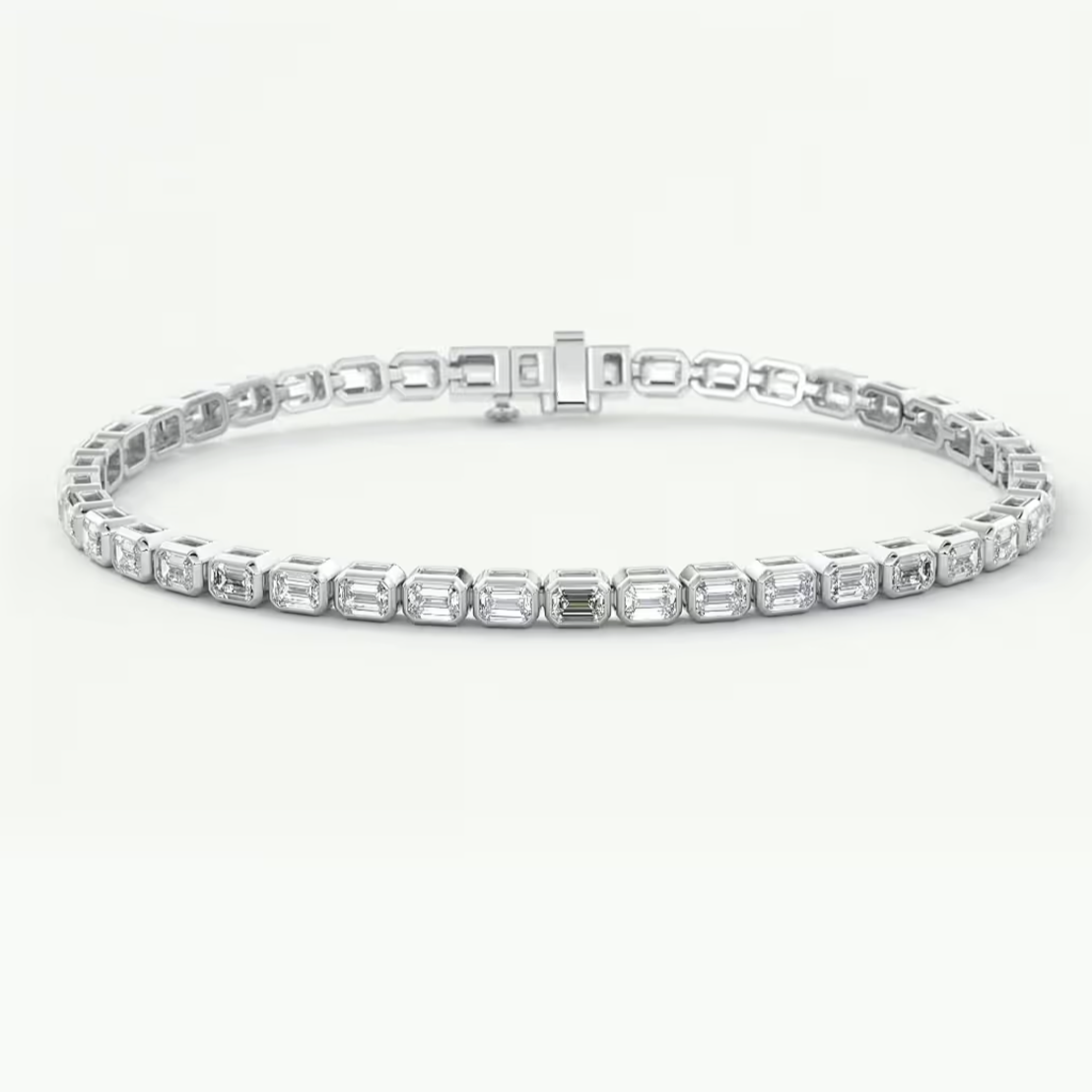 A white gold tennis bracelet featuring a row of baguette-cut clear gemstones in a continuous link design, displayed on a clean white background.