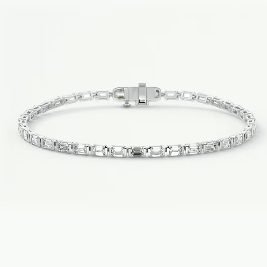 A silver tennis bracelet featuring a row of baguette-cut clear gemstones, displayed on a clean white background.