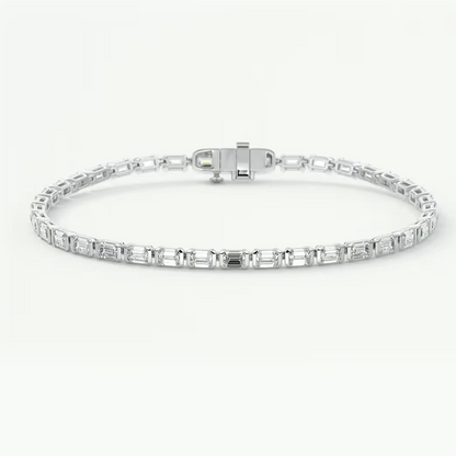 A silver tennis bracelet featuring a row of baguette-cut clear gemstones, displayed on a clean white background.