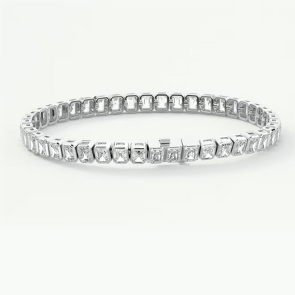 A platinum tennis bracelet featuring a continuous row of baguette-cut clear gemstones in a prong setting, displayed against a clean white background.
