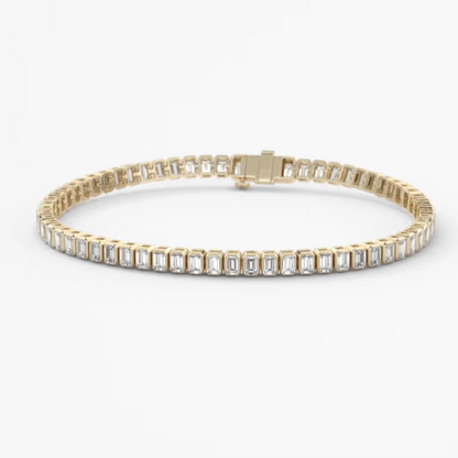 A yellow gold tennis bracelet featuring a row of baguette-cut clear gemstones, displayed on a clean white background.