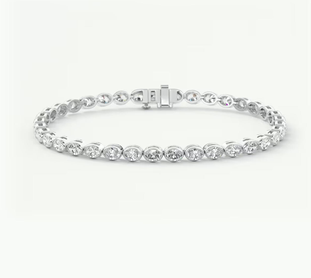 A white gold tennis bracelet with round-cut clear stones in a prong setting, featuring a sliding clasp, shown on a plain light background.