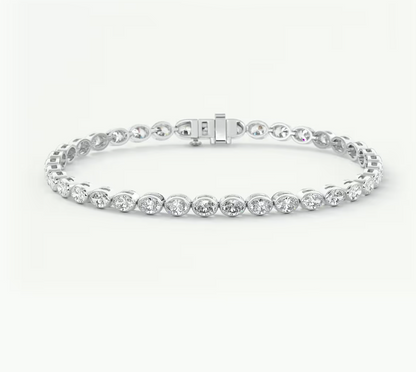 A white gold tennis bracelet with round-cut clear stones in a prong setting, featuring a sliding clasp, shown on a plain light background.