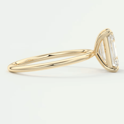 18-karat yellow gold engagement ring with a baguette-cut diamond.