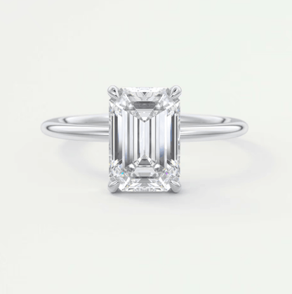 18-karat white gold emerald-cut diamond engagement ring.