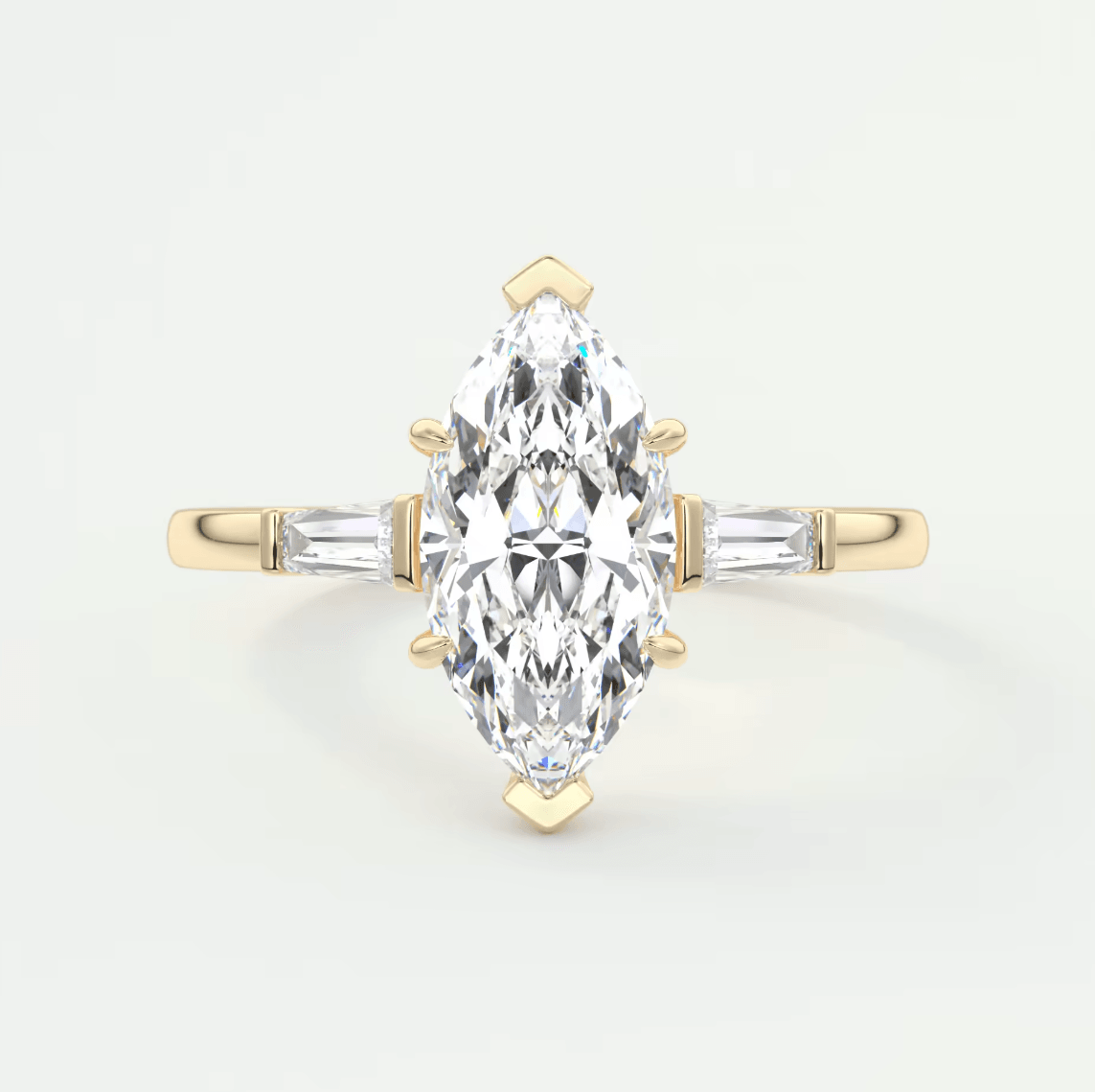 18-karat yellow gold marquise-cut diamond engagement ring with baguette side stones.