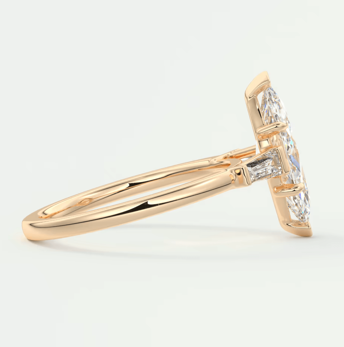 18-karat gold diamond engagement ring with a marquise-cut center stone and baguette diamonds on either side.